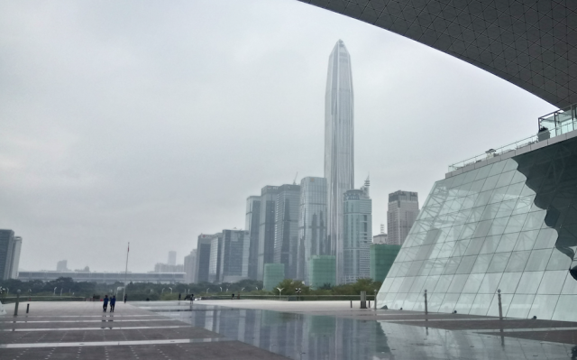 This has been the future. Under the arch of the Shenzhen Civic Center, tiny humans are reflected on a vast marbled plain and the Ping An Tower rises over skyscraper custer in Futian. It